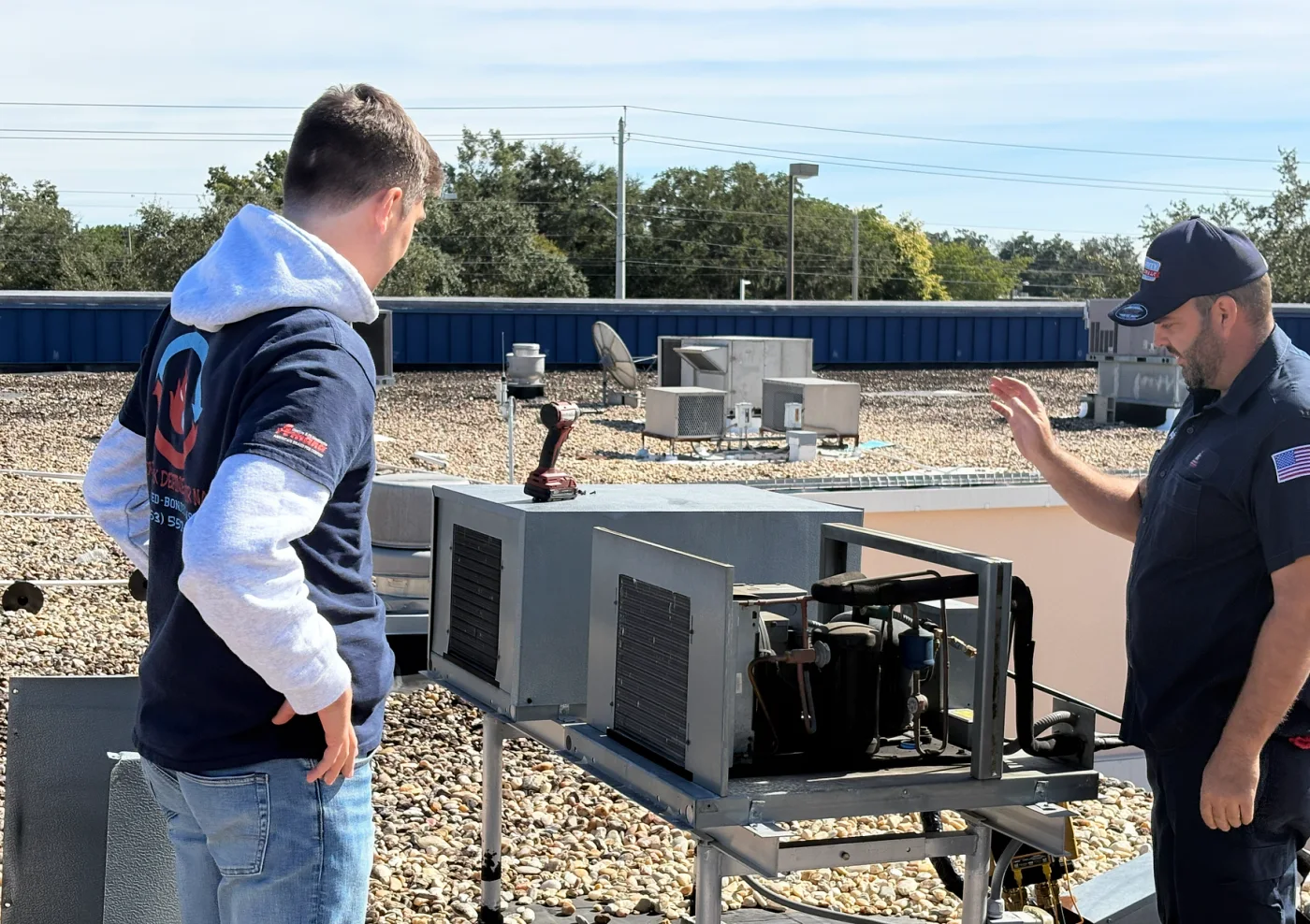Spencer and Yandy inspecting HVAC equipment on a roof